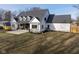 White farmhouse-style home with a gray roof, large backyard, and patio at 5119 E 71St St, Indianapolis, IN 46220