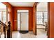 Inviting foyer with a white front door, bright orange walls, and tile flooring at 5838 W Bayfield Dr, McCordsville, IN 46055