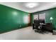Bright home office featuring green walls, neutral carpet, and a dark wood desk with a computer setup at 5838 W Bayfield Dr, McCordsville, IN 46055