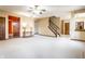 An expansive living room with neutral walls and a wooden staircase leading to the upper level of the home at 5838 W Bayfield Dr, McCordsville, IN 46055