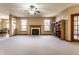 Spacious living room featuring a fireplace, large bookshelf, and ample natural light from large windows at 5838 W Bayfield Dr, McCordsville, IN 46055