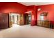 Expansive main bedroom with red walls, offering ample space and multiple doorways to adjoining rooms at 5838 W Bayfield Dr, McCordsville, IN 46055