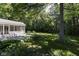 Lush backyard with paver patio, mature trees, and a covered porch at 9275 Eastwind Dr, Indianapolis, IN 46256