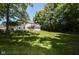 Spacious backyard with white house, screened-in porch, and large grassy area at 9275 Eastwind Dr, Indianapolis, IN 46256