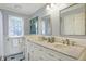 Traditional-style bathroom featuring double vanity with carrara marble countertop and decorative mirrors at 9275 Eastwind Dr, Indianapolis, IN 46256