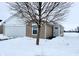 Exterior view of charming ranch home with white garage door and snowy yard at 1608 Wagner Dr, Shelbyville, IN 46176