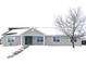 Ranch home with gray siding, blue shutters, and snowy front yard at 1685 Juniper Dr, Columbus, IN 47201