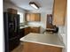 Galley kitchen with wood cabinets and black appliances at 17773 Captiva Way, Westfield, IN 46062