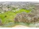 Aerial view capturing the home nestled amongst mature trees with stunning greenery and river backdrop at 2940 Washington St, Columbus, IN 47201