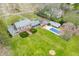 Aerial view of a brick home with a pool, well-manicured lawn, and surrounding trees at 2940 Washington St, Columbus, IN 47201