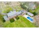 Aerial view of a brick home with a pool, well-manicured lawn, and surrounding trees at 2940 Washington St, Columbus, IN 47201