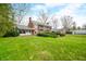 Large grass backyard with brick home, screened porch, and balcony at 2940 Washington St, Columbus, IN 47201