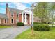 Beautiful brick home featuring grand white columns, manicured bushes, and a vintage lamp post at 2940 Washington St, Columbus, IN 47201