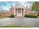 Impressive brick home showcasing prominent columns, a second-story balcony, and symmetrical design at 2940 Washington St, Columbus, IN 47201