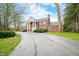 Elegant brick home with a symmetrical facade, prominent white columns, and a sprawling driveway at 2940 Washington St, Columbus, IN 47201