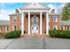 Close-up of a stately brick home entrance, highlighting elegant white columns and a charming balcony at 2940 Washington St, Columbus, IN 47201