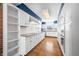 White kitchen with blue walls, wood floors, and a built-in shelving unit at 2940 Washington St, Columbus, IN 47201