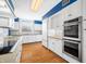 White kitchen with blue walls, wood floors, and stainless steel appliances at 2940 Washington St, Columbus, IN 47201