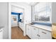 White kitchen with blue accents, wood floors, and a window at 2940 Washington St, Columbus, IN 47201