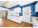 White kitchen with blue walls, wood floors, and stainless steel appliances at 2940 Washington St, Columbus, IN 47201