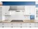 Kitchen features white cabinets, a stainless steel range hood, and marble backsplash at 2940 Washington St, Columbus, IN 47201