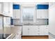 White kitchen with blue walls, wood floors, and stainless steel appliances at 2940 Washington St, Columbus, IN 47201