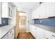 White kitchen with blue walls, wood floors, and a view of a dining room at 2940 Washington St, Columbus, IN 47201