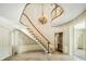 Grand curved staircase with chandelier and patterned wallpaper at 2940 Washington St, Columbus, IN 47201