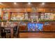 Fully stocked home bar with display shelving and a decorative Christmas garland at 3264 W Roberts Rd, Trafalgar, IN 46181