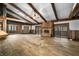 Rustic living room with exposed beams, stone fireplace, and hardwood floors at 3264 W Roberts Rd, Trafalgar, IN 46181