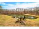 Serene pond with wooden dock and surrounding trees and grassy areas at 3264 W Roberts Rd, Trafalgar, IN 46181