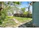 Large grassy backyard with a stone pathway and privacy fence with mature trees at 35 S Catherwood Ave, Indianapolis, IN 46219