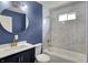 A bathroom with white marble tile surround tub and modern fixtures and navy accent wall at 35 S Catherwood Ave, Indianapolis, IN 46219