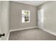 A bright bedroom with neutral walls and carpet with view of trees through the window at 35 S Catherwood Ave, Indianapolis, IN 46219