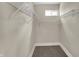 The walk-in closet features built-in shelving and neutral colored walls and carpet at 35 S Catherwood Ave, Indianapolis, IN 46219