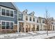 Two-story townhome with front porch, stone accents, and snow-covered landscaping at 3921 Wren Dr, Brownsburg, IN 46112