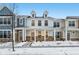 Two-story townhome with front porch, stone accents, and snow-covered landscaping at 3921 Wren Dr, Brownsburg, IN 46112