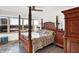 Main bedroom with a four-poster bed, ceiling fan, and city views at 3965 N Meridian St # Apt 6C, Indianapolis, IN 46208
