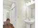 Bright bathroom with a pedestal sink, updated fixtures, and a view of the hallway with wood flooring and closet space at 4103 Railhead Ave, Westfield, IN 46074