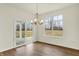 Inviting dining room features wood floors, stylish chandelier, and sliding doors for outdoor access at 4103 Railhead Ave, Westfield, IN 46074