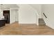Bright open-concept living room featuring hardwood floors and a staircase with carpeted steps at 4103 Railhead Ave, Westfield, IN 46074