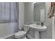 Clean bathroom with pedestal sink, toilet, and gray tile floor at 4223 Mardale Ln, Bargersville, IN 46106
