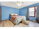 Bright bedroom with light blue walls, hardwood floors, and a ceiling fan at 457 S High School Rd, Indianapolis, IN 46241