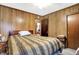 Bedroom with wood paneled walls, hardwood floors, and ceiling fan at 457 S High School Rd, Indianapolis, IN 46241