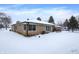 Back exterior of ranch home, snow covered yard at 457 S High School Rd, Indianapolis, IN 46241