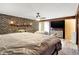 Main bedroom with brick wall, ceiling fan, and large TV at 457 S High School Rd, Indianapolis, IN 46241