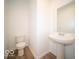 Charming half bathroom featuring a pedestal sink, toilet, hardwood floors, and neutral paint at 6039 Granby Dr, Whitestown, IN 46075