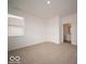 Bright bedroom with a window, door, and neutral carpet flooring at 6039 Granby Dr, Whitestown, IN 46075