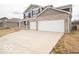 Long driveway and attached two-car garage of this charming home featuring a brick facade and gray siding at 6039 Granby Dr, Whitestown, IN 46075
