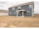 Back exterior of a blue sided home with a covered patio on a partially landscaped lot at 6039 Granby Dr, Whitestown, IN 46075